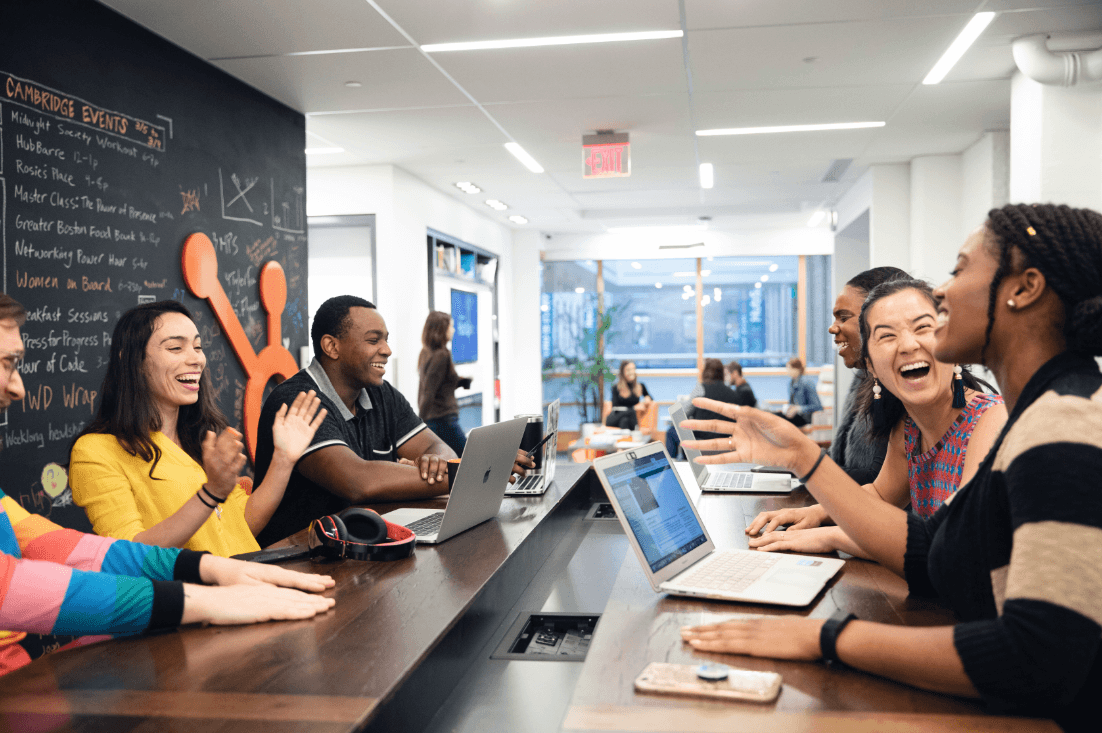 HubSpot team members laughing together at their desks